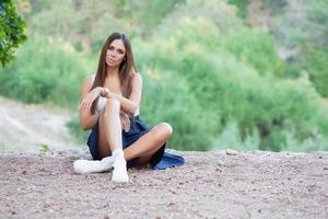 charmant brunette posant séance sur une sentier photo