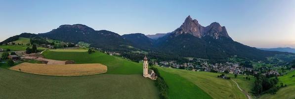 st. Valentin castelruth village église dans le été dans le dolomie Alpes. incroyable paysage avec petit chapelle sur ensoleillé Prairie et petz de pointe à castelruth commune. dolomites, Sud Tyrol, Italie photo