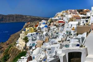 charmant vue oia village sur Santorin île, Grèce. traditionnel célèbre bleu dôme église plus de le caldeira dans égéen mer. traditionnel bleu et blanc cyclades architecture. photo