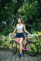 Portrait d'une femme avec un vélo rose au parc photo