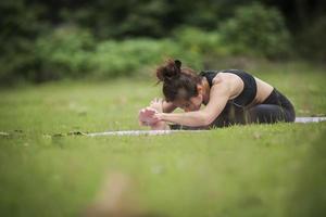 femme faisant du yoga dans le parc