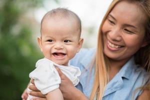 mère et bébé riant et jouant au parc photo