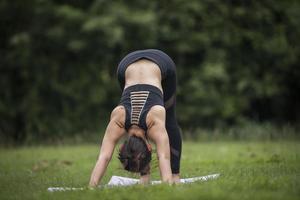 femme faisant du yoga dans le parc