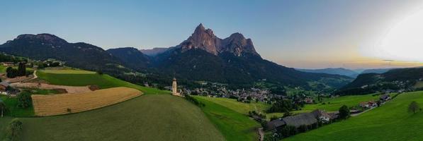 st. Valentin castelruth village église dans le été dans le dolomie Alpes. incroyable paysage avec petit chapelle sur ensoleillé Prairie et petz de pointe à castelruth commune. dolomites, Sud Tyrol, Italie photo