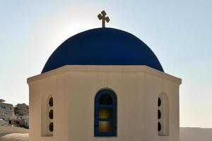 charmant vue oia village sur Santorin île, Grèce. traditionnel célèbre bleu dôme église plus de le caldeira dans égéen mer. traditionnel bleu et blanc cyclades architecture. photo