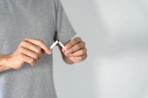 NE PAS FUMER. l'homme arrête de fumer, refuse, rejette, casse, prend une cigarette, dis non. arrêter de fumer pour la santé. journée mondiale du tabac. médicaments, cancer du poumon, emphysème, maladie pulmonaire, narcotique, effet nicotine photo