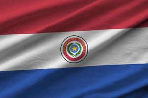 drapeau du paraguay avec de grands plis agitant de près sous la lumière du studio à l'intérieur. les symboles et couleurs officiels de la bannière photo