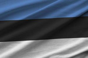 drapeau estonien avec de grands plis agitant de près sous la lumière du studio à l'intérieur. les symboles et couleurs officiels de la bannière photo