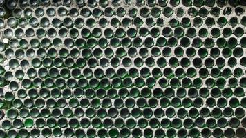 une mur de vert du vin bouteilles. solide texture clôture de le bas photo