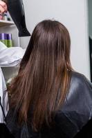 une chevelure brune droite et saine qui a subi la procédure de lissage des cheveux. cheveux bruns lisses, brillants et sains photo