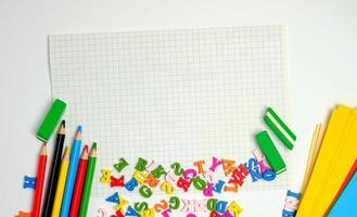 école Provisions multicolore en bois des crayons, carnet de notes, coloré papier et Vide blanc feuille dans une case à cocher photo