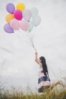 petite fille jouant avec des ballons sur le champ de prés photo