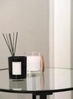 parfumé bougies et arôme diffuseur avec des bâtons sur branché verre chevet tableau. moderne intérieur détails photo