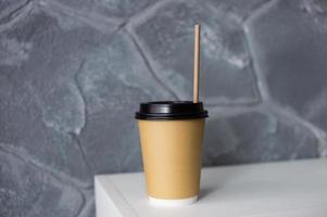 une jetable respectueux de la nature papier tasse avec une paille est sur le étagère photo