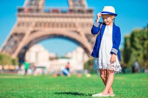 peu fille dans de face de le Eiffel la tour, Paris - France photo