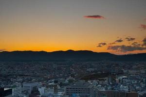 lever du soleil sur une ville avec des montagnes photo