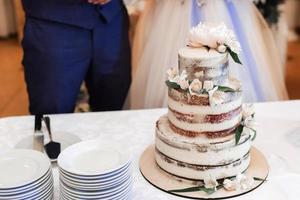 une magnifique mariage gâteau des stands sur le table suivant à le la mariée et jeune marié photo