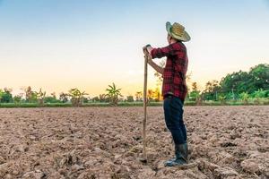 agriculteur travail sur champ à le coucher du soleil Extérieur photo