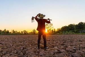 agriculteur travail sur champ à le coucher du soleil Extérieur photo
