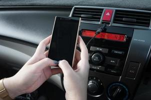 main tenir téléphone intelligent dans voiture, gens presse le téléphone tandis que conduite photo