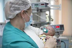 infirmière avec une bébé dans intensif se soucier. nouveau née bébé dans le hôpital. photo