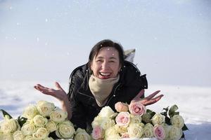 content personnes âgées femme avec une bouquet de fleurs dans l'hiver. photo