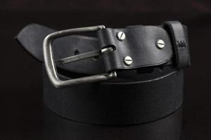 ceinture en cuir noir sur fond sombre. produits en cuir. photo