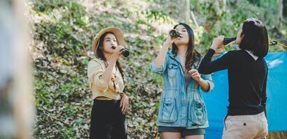 jeune femme applaudir et boire une boisson devant la tente de camping photo