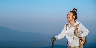 portrait d'une jeune femme touristique asiatique fait de la randonnée au sommet du montage et regarde un beau paysage avec espace de copie photo