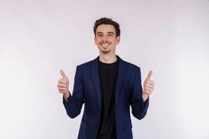 portrait de content souriant Jeune homme d'affaire montrant les pouces en haut geste et à la recherche à caméra sur isolé plus de blanc Contexte photo