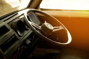 proche en haut de le pilotage roue de un abandonné rouillé vieux voiture.vieux voiture intérieur, ancien photo