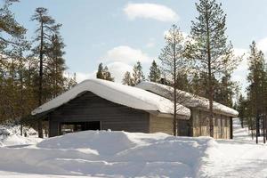 en bois maison dans une forêt avec neige. Laponie photo
