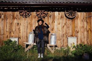 femme assise sur un banc avec des bidons de lait dans une ferme photo