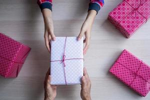 le enfant est recevoir une cadeau de le sien mère sur sa anniversaire. photo