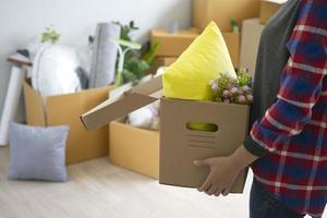 femme est porter le boîte pour personnel articles. préparer à bouge toi à une Nouveau maison. photo