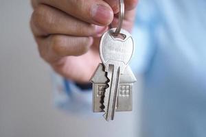 le propriétaire déverrouille la clé de la maison pour une nouvelle maison photo