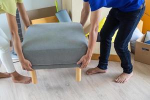 des couples aidé chaque autre porter des choses dans nombreuses papier des boites. et levage meubles à préparer à bouge toi maison. photo