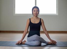 femmes sont Faire assise torsion des exercices pour santé et une plus ferme corps. yoga concept photo