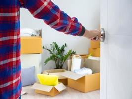 le Nouveau Accueil propriétaire ouvre le porte de le chambre. à l'intérieur le pièce là sont personnel affaires cette sont Aller à être déplacé à garder correctement. maison en mouvement concept. photo