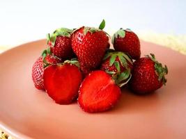 Frais des fraises empilé sur une rose assiette photo