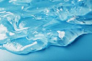 gel avec hyaluronique acide dans le forme de une diffamer de brillant texture sur une bleu Contexte. photo