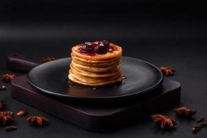 délicieux Frais Crêpes avec baie confiture sur une noir céramique assiette photo