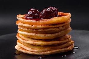 délicieux Frais Crêpes avec baie confiture sur une noir céramique assiette photo