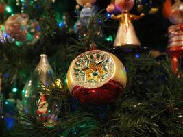 Boule de Noël faite à la main en verre sur l'arbre de Noël feux de flou détail photo