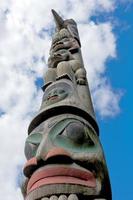 un poteau en bois de totem dans le fond bleu nuageux photo