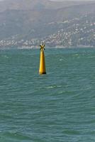 Jaune non voile métallique bouée sur bleu mer Contexte photo