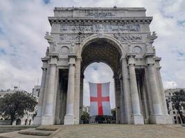 triomphe arc dans Gênes avec drapeau rouge traverser dans blanc photo