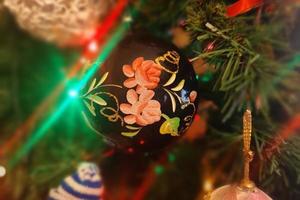 Boule de Noël faite à la main en verre sur l'arbre de Noël feux de flou détail photo