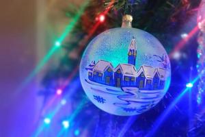 Boule de Noël faite à la main en verre sur l'arbre de Noël feux de flou détail photo