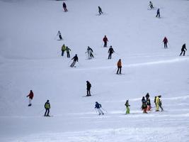 de nombreux skieurs skiant dans les montagnes de neige de la vallée de Gardena dolomites photo